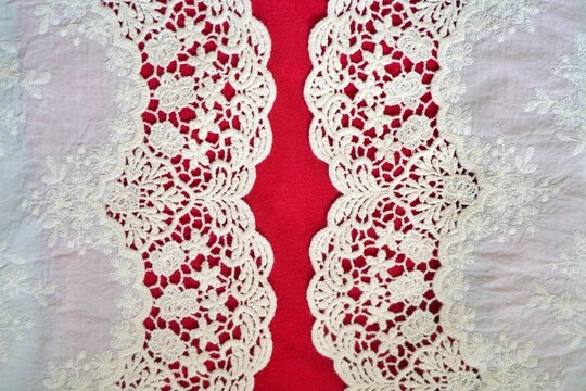 Curved scalloped lace framing both sides on red background, leaving a central stripe for a balanced and elegant textile composition