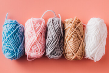 Colorful Yarn Bundles on a Soft Pink Background for Craft Projects