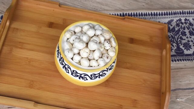 showing raw phool makhana on a wooden tray