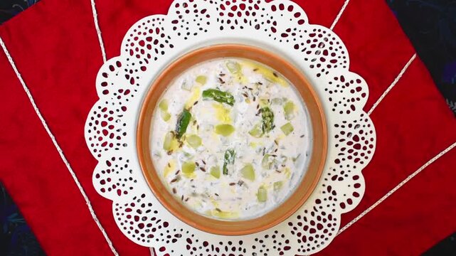 Bowl having curd or raita topped with cumin chili dadka. indian side dish