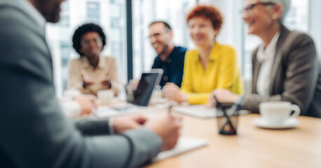 Business people smiling and collaborating around a table indoors, expressing teamwork, motivation, and success in a bright professional setting filled with creativity and positive energy.
