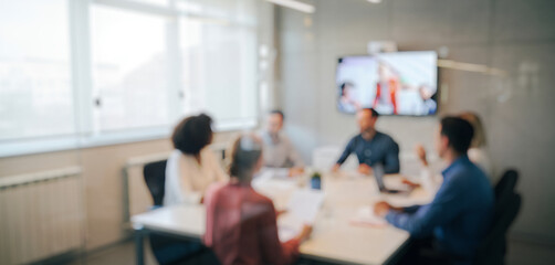 People meeting around a table in a bright modern office setting, exchanging ideas and strategies in a collaborative workspace that highlights teamwork, focus, and professional energy.