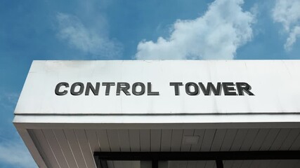 Control Tower word sign displayed on the exterior of a tall, modern building under a clear blue sky, symbolizing air traffic control, monitoring, coordination, and aviation management