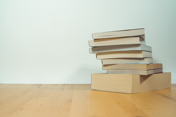 stack of book on table with soft focus library or bookstore background