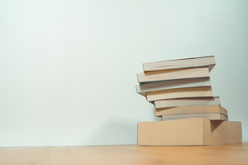 stack of book on table with soft focus library or bookstore background