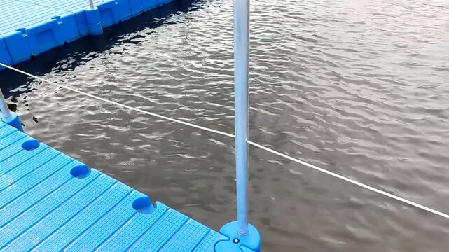 Travel sports Urban marina with pontoon and boundary rope camera movement calm water beach infrastructure content for tourism boating