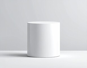 White cylinder pedestal on white surface, grey backdrop