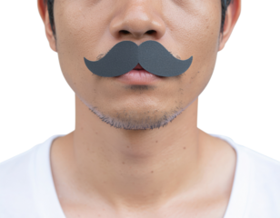 A man poses with a playful black paper mustache above his upper lip, showcasing a humorous and lighthearted expression.
