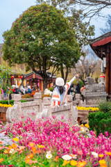 Young female tourist enjoying at Lijiang Ancient Town, the famous tourist destination in Yunnan Province, China