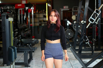 Fototapeta premium Young woman standing in gym ready for workout