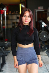 Fototapeta premium Young woman standing in gym creating fitness content