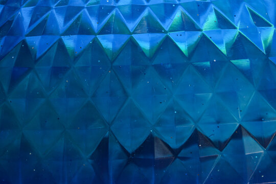 blue surface texture with triangular geometric patterns and light reflection effects