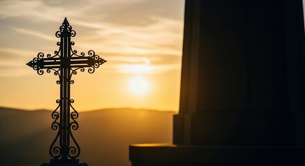 Naklejka premium Ornate Cross Silhouette Against a Golden Sunset Sky.