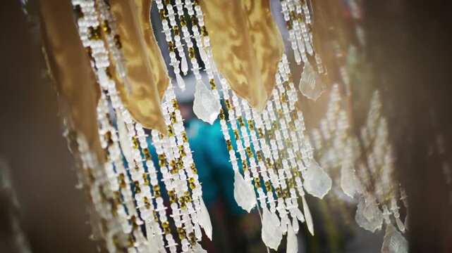 Close-up of Traditional Bugis Wedding Decoration with Hanging Beads and Gold Fabric