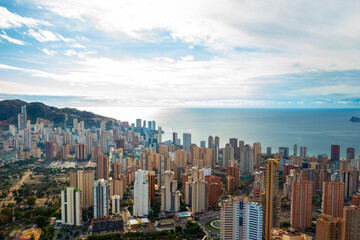 Stunning panoramic view of Benidorm city with tall modern skyscrapers, sandy beach, and turquoise Mediterranean Sea. Beautiful coastal skyline of Costa Blanca, Alicante Province, Spain. Perfect urban