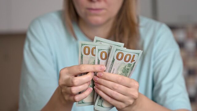 A person counts cash while worried about rising utility costs. This moment captures the stress and concern many face in managing household expenses effectively.