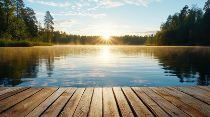 Sunrise over tranquil lake with mist rising, reflecting trees and sky