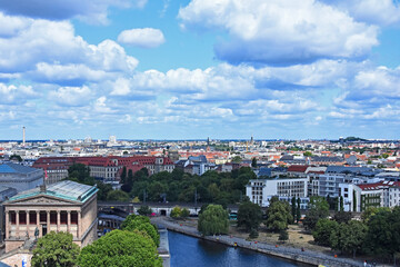 Fototapeta premium Panoramic aerial view of Berlin's historic Mitte district, showing the Spree River, Museum Island with the Berliner Dom, and the Fernsehturm landmark under a dramatic sky.
