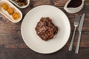 Juicy grilled beef steak served with sauce and sides