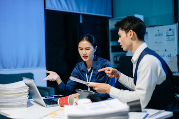 Asian manager scolding employee under stress, workplace conflict and frustration in modern office showing tension and miscommunication.