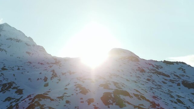 Majestic snow-covered mountains, bright sun creates lens flare over pristine alpine landscape, Italy. Aerial drone, copy space