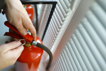 hand presses the trigger fire extinguisher available in fire emergencies conflagration damage...