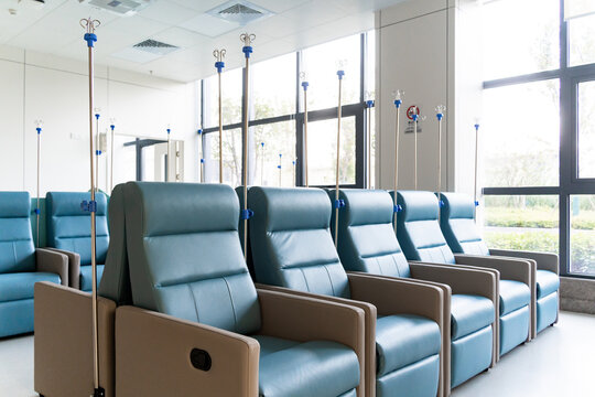 hospital infusion area with blue recliners and IV poles
