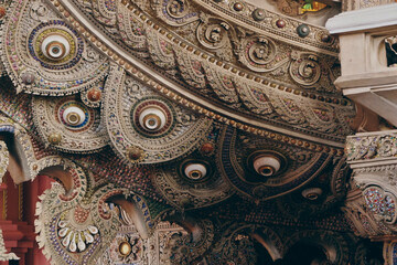 Decorative architectural carving featuring circular dragon-inspired motifs and layered textures from the Erawan Museum interior.