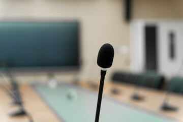 modern conference room with a large screen, multiple microphones