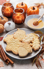 Autumn cookies, candles, pumpkins, honey, and cinnamon decorating table