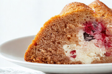 Close up of a slice of bundt cake with berries and cream filling