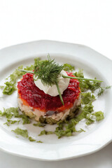 Elegant layered appetizer with vibrant red topping and green garnish
