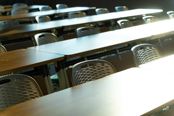 spacious conference room with rows of tables white chairs