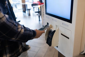 Closeup man Counter Buy electronic payment supermarket smartphone male hand with a mobile phone in pay for purchases in stores Contactless NFC Terminal Close Up card reader.