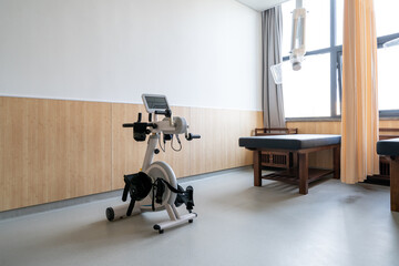 rehabilitation exercise bike with a screen and straps with massage bed in a TCM clinic
