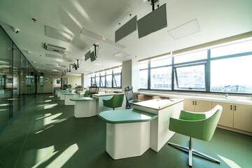 bright office in hospital with green furniture, large windows, and modern decor