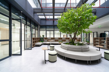 bright atrium with a large tree, modern seating, and glass roof, creating a vibrant indoor garden...
