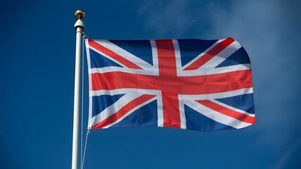United Kingdom flag waving in the wind against clear blue sky, national symbol of Great Britain, patriotism, freedom, and British cultural identity background