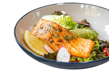 A delicious cooked salmon fillet on a bed of fresh greens and lemon wedges. The dish has a vibrant, appetizing appeal.