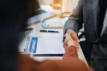 Middle age partner lawyers attorneys shaking hands after discussing a contract agreement done.
