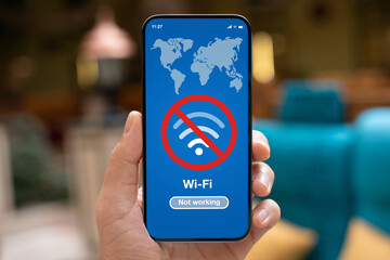 man hand holds phone with Wi-Fi banned on screen cafe