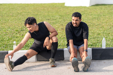Asian Indonesian Men Resting and Drinking Water After Running