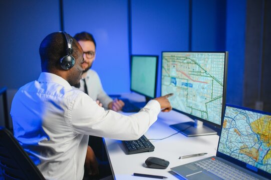 Center of dispatching maintenance. Portrait of men working via headset microphone while sitting on navigation controller board