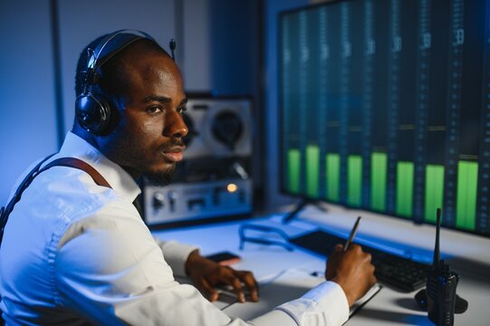 African american police officer records a telephone conversation on a tape recorder. secret agent