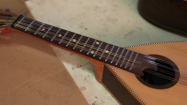 A stringed Asian instrument is lying on the workshop table.
