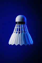 Floating shuttlecock display against a vibrant blue background showcasing dynamic sports energy