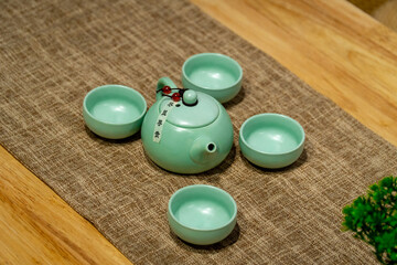 A set of jade green teapot on a cloth pad on the table.