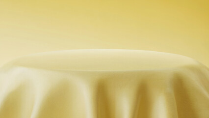 Round table draped in soft yellow fabric against a pale yellow backdrop cloth