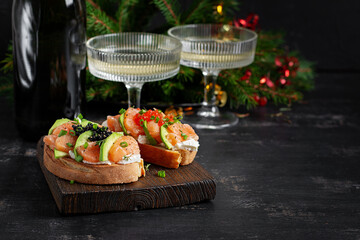 Avocado and salmon appetizer on the Christmas table. Canapes with fish and caviar.