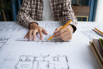 Architect Interior Design drawing on blueprint with solar panel home model